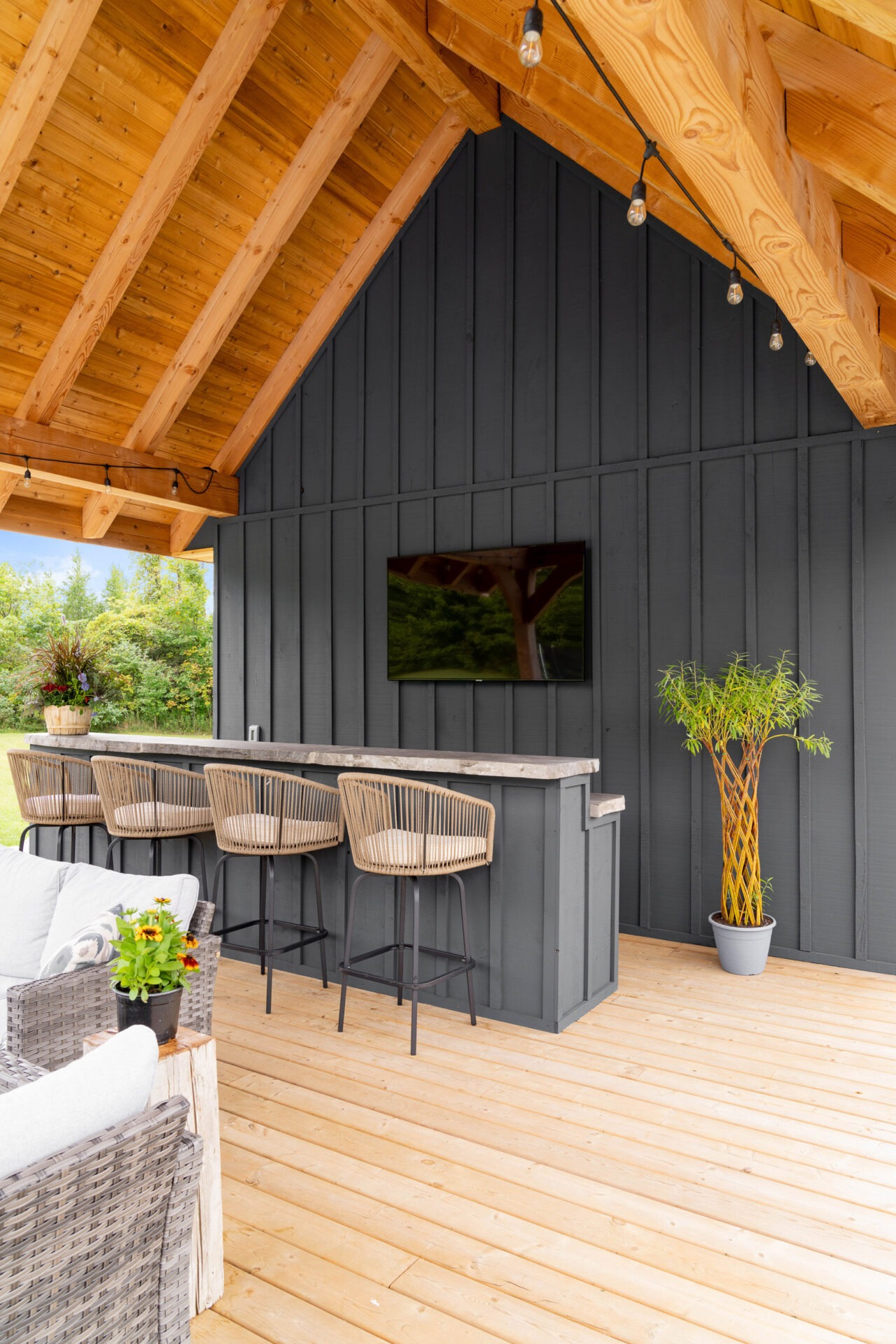 this image shows an outdoor living room, an outdoor bar, and an outdoor TV area