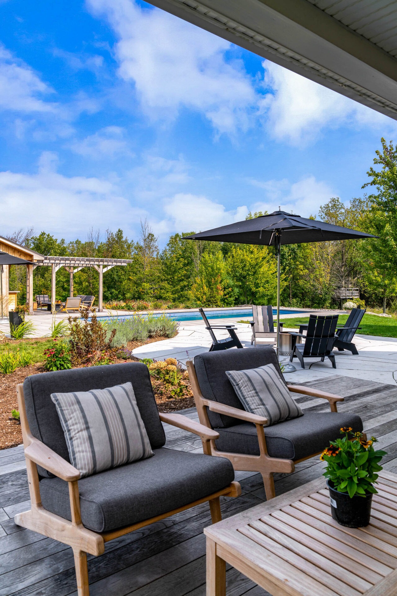 this image shows an outdoor living room on a flagstone patio and thermory deck