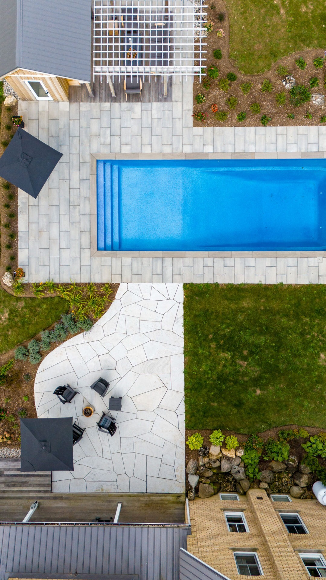 this image shows a swimming pool, pool house with sauna, pergola, outdoor living room with television and bar, pollinator gardens